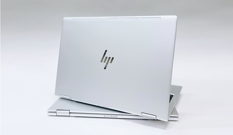En silvrig HP-laptop som stör öppnad på en stängd likadan dator.